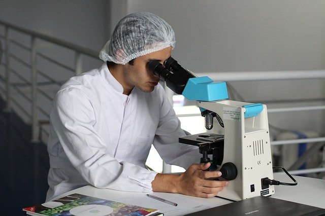 vědec kouká do mikroskopu